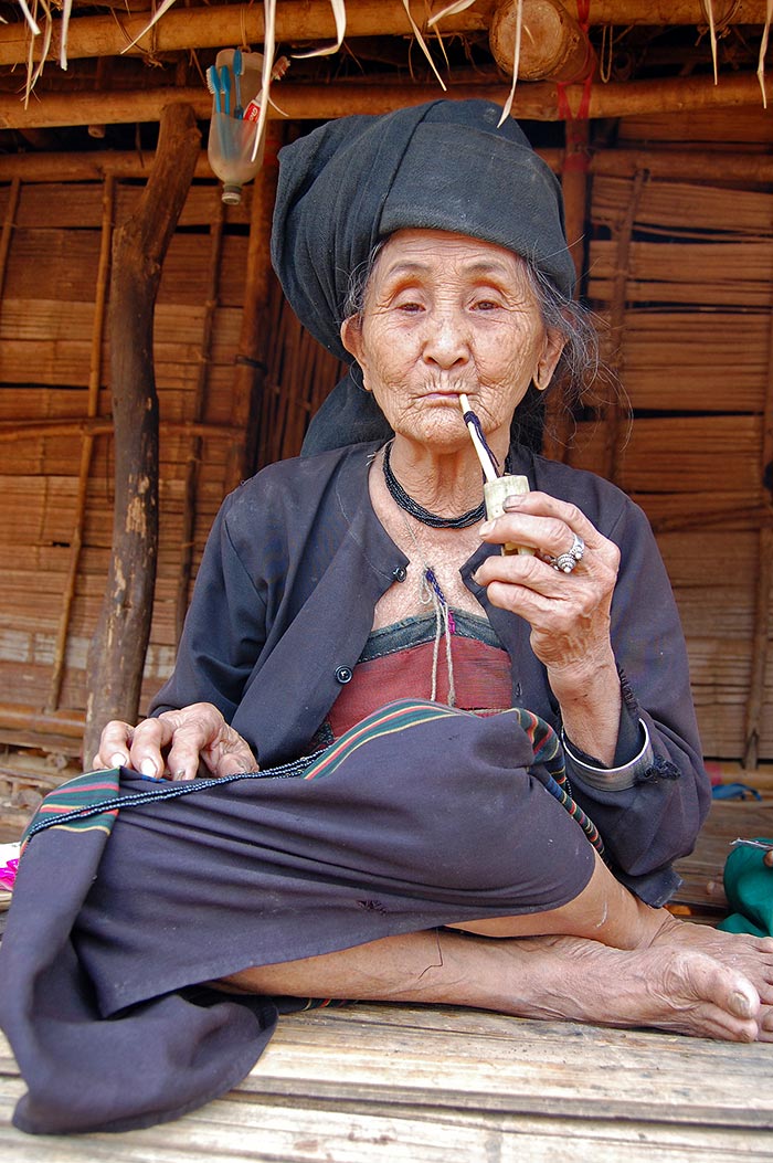 A pipe smoking Akhu woman.