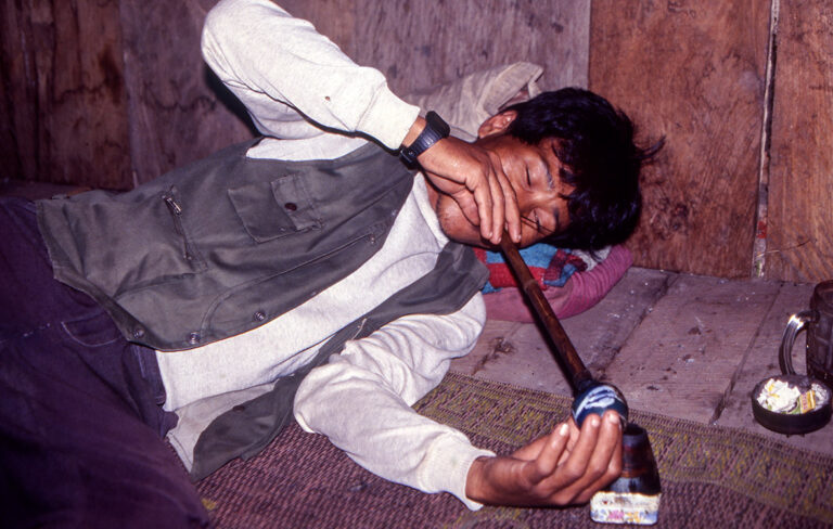 Lahu man smoking opium.