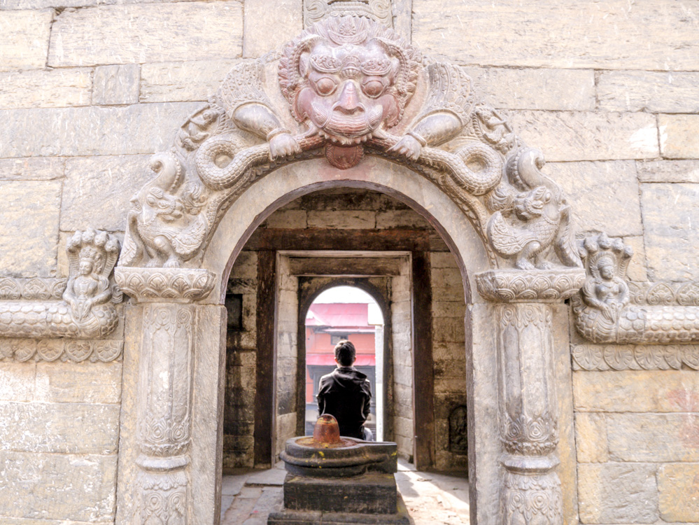 man sitting in front of a small shrine in Cremation temple man sitting in front of a small shrine in Cremation temple